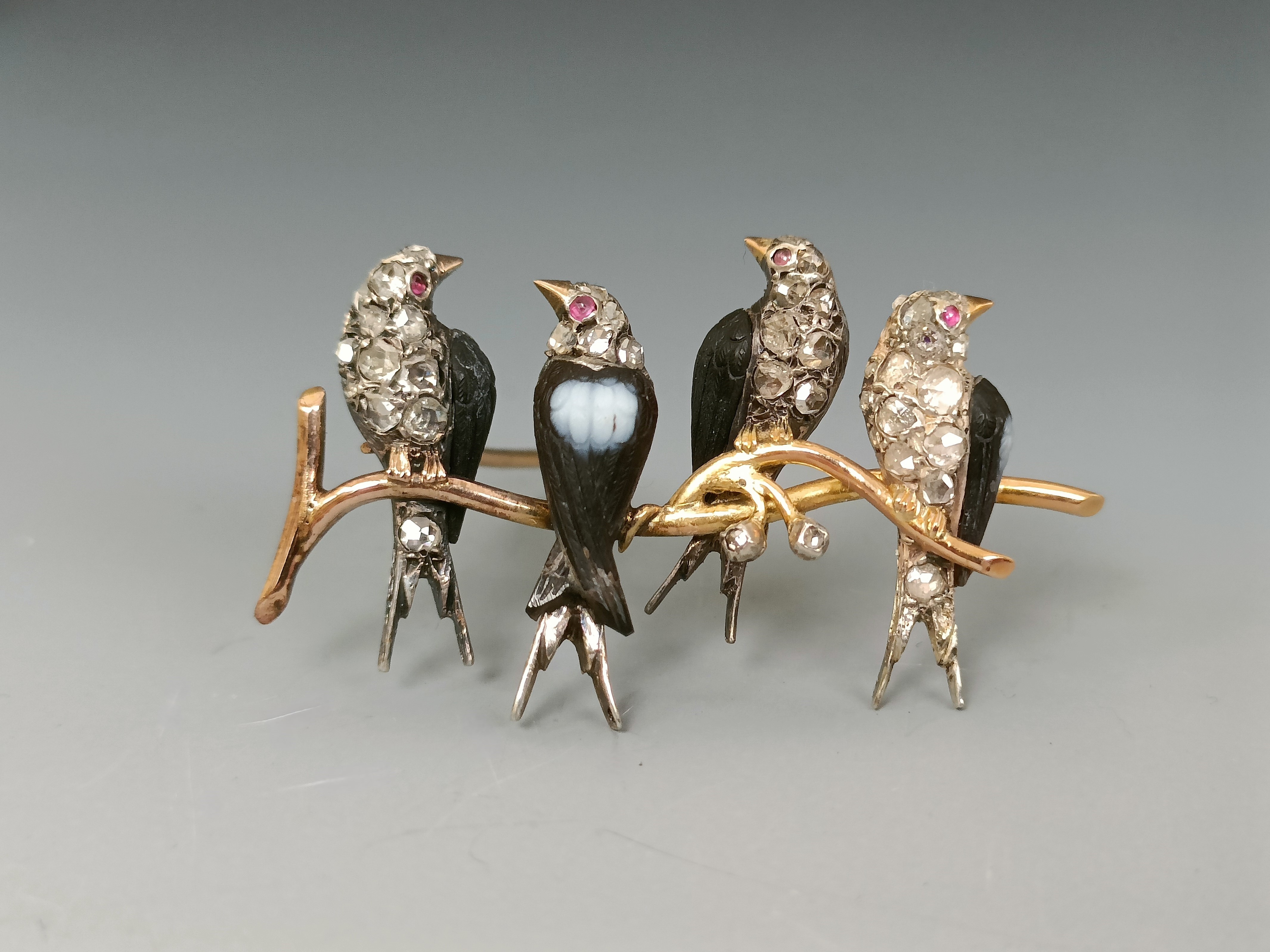 A brooch, four birds perched on a branch